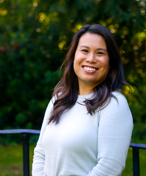 Woman with long, dark hair is smiling light blue sweater