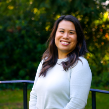 Woman with long, dark hair is smiling light blue sweater