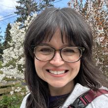 Headshot of Jenni Campbell, Assistant Director of Academic & Student Services, smiling in front of a flowering tree