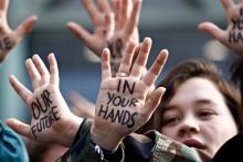 Students' hands painted with messages like, 'in your hands'